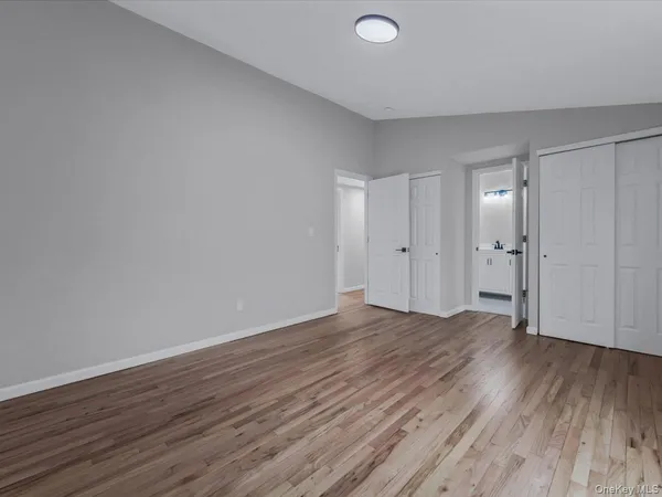 a bedroom with a large bed a potted plant and a window