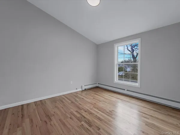 a bedroom with a bed a table and a potted plant