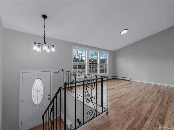 a view of a room with wooden floor fan and windows