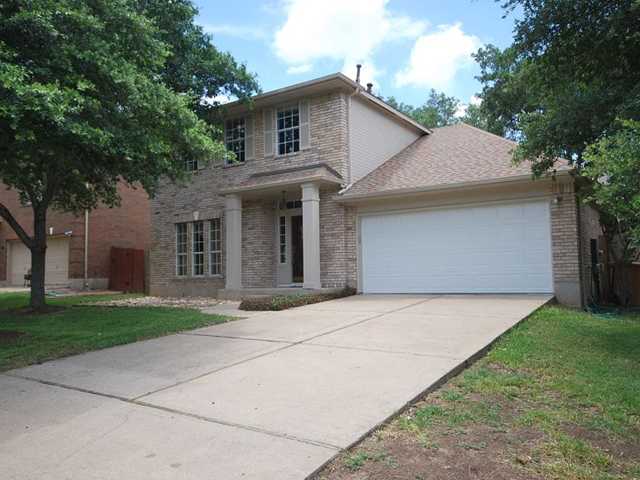 10716 Redmond Road Austin, TX 78739 - Photo 1 of 1 a front view of a house with a garden and trees
