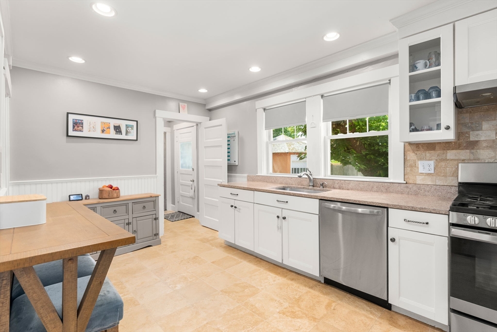 17 Maple Street, Unit 17 Needham, MA 02492 - Photo 12 of 24 a kitchen with stainless steel appliances granite countertop a stove a sink dishwasher and a refrigerator with white cabinets
