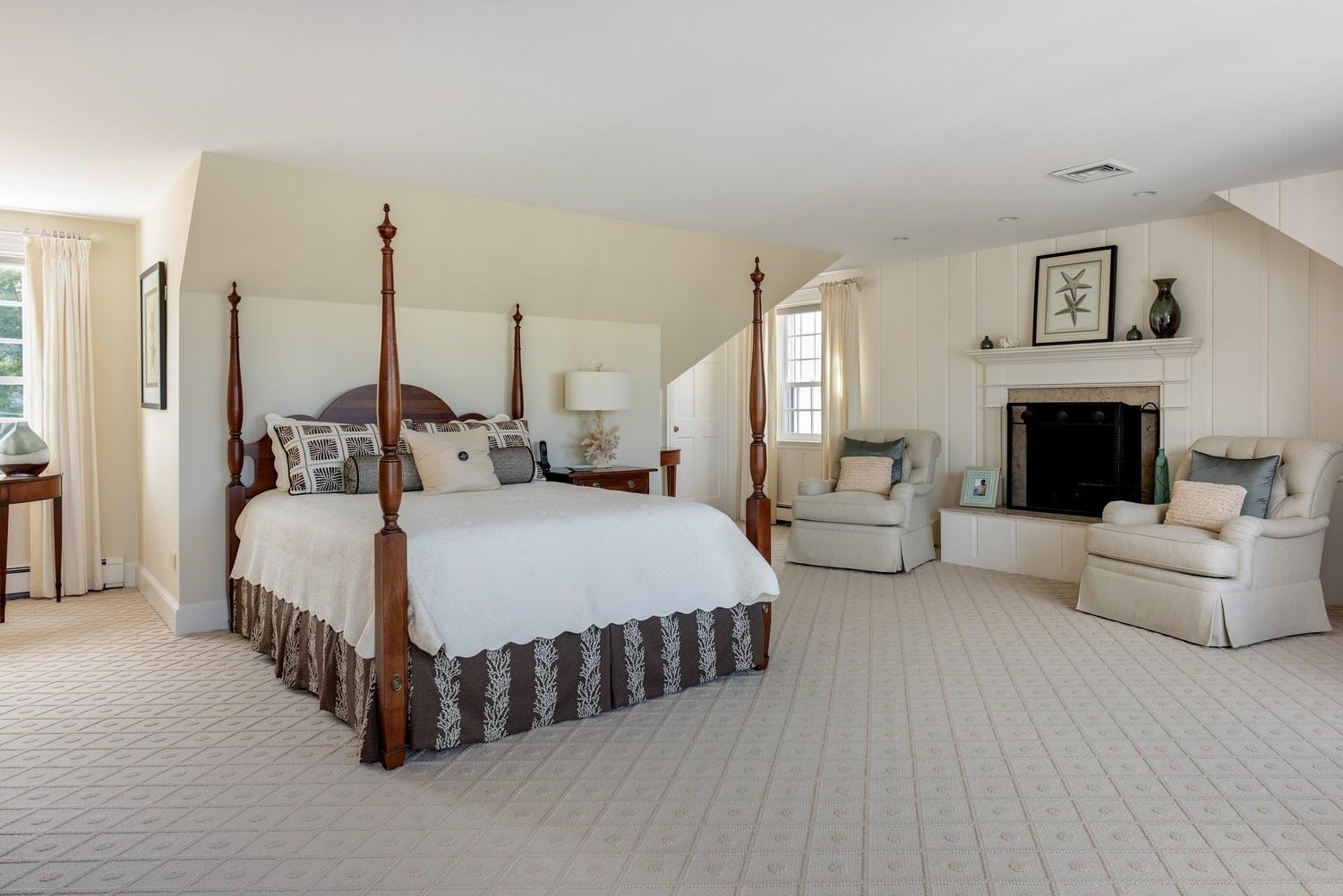 56 Rendezvous Lane Barnstable, MA 02630 - Photo 26 of 35 a spacious bedroom with a bed a couch and a fireplace
