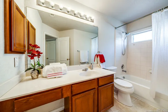 a bathroom with a granite countertop sink mirror and toilet