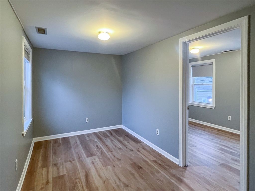 19-25 Common Street Weymouth, MA 02188 - Photo 11 of 41 an empty room with wooden floor and windows