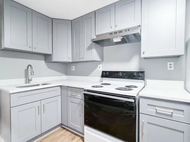 a kitchen with granite countertop white cabinets and white appliances