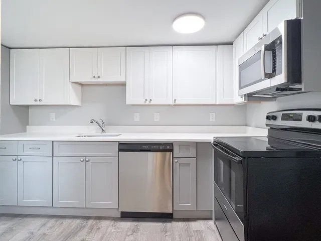 a kitchen with stainless steel appliances granite countertop a sink stove and cabinets