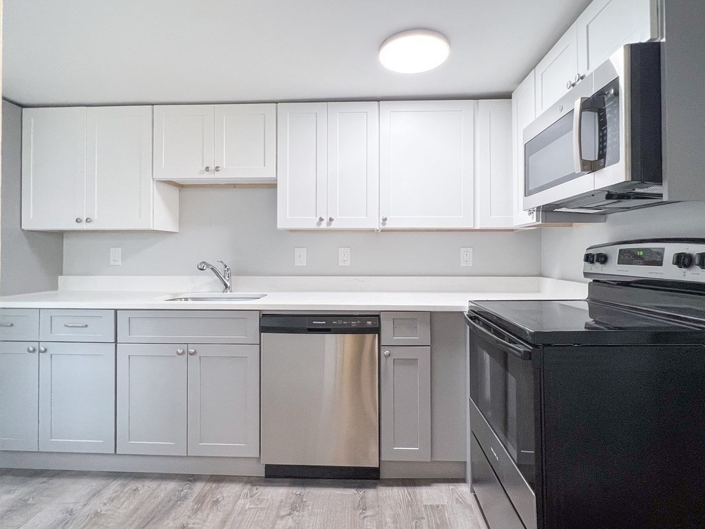 19-25 Common Street Weymouth, MA 02188 - Photo 24 of 41 a kitchen with stainless steel appliances granite countertop a sink stove and cabinets