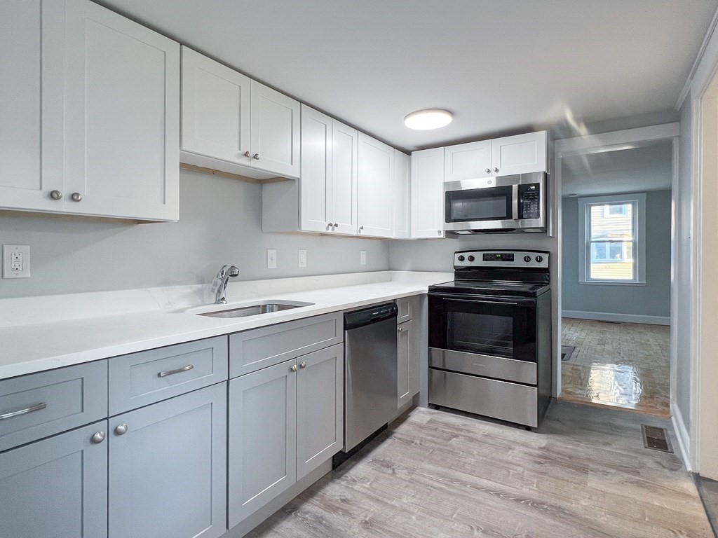 19-25 Common Street Weymouth, MA 02188 - Photo 25 of 41 a kitchen with cabinets stainless steel appliances and a sink