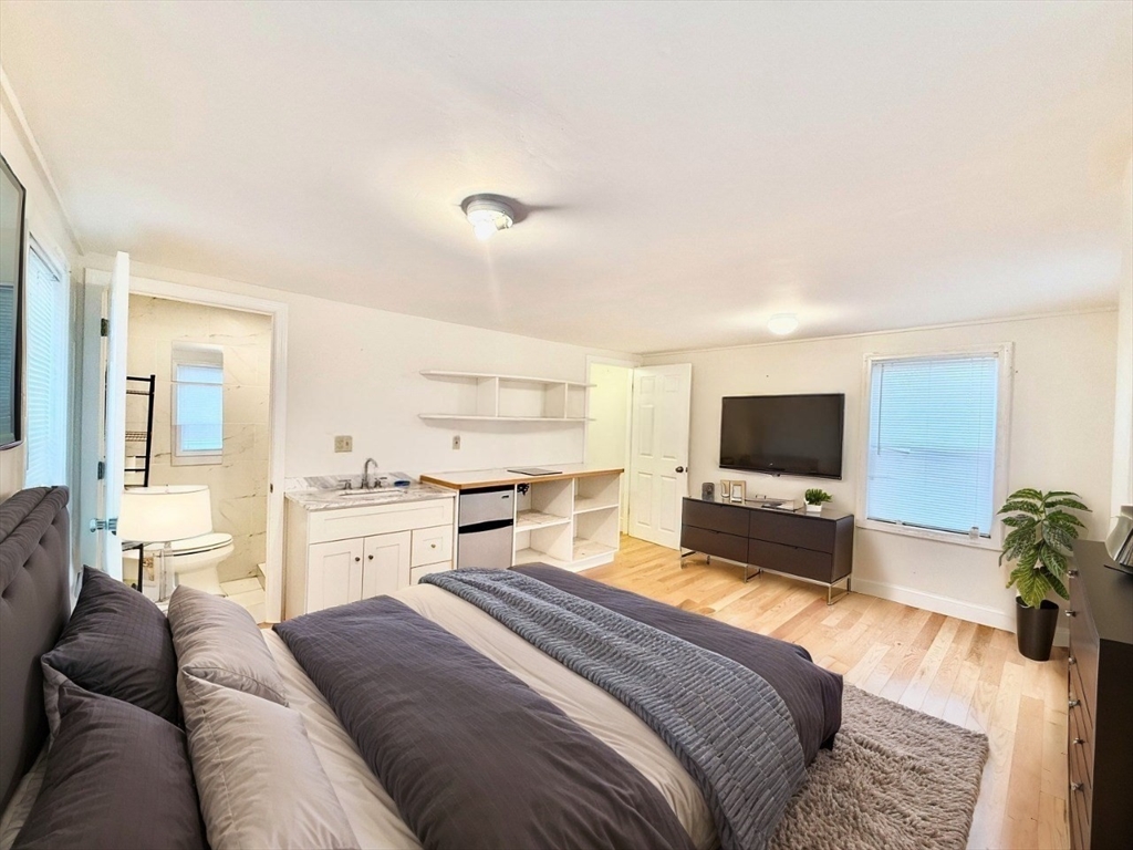 19-25 Common Street Weymouth, MA 02188 - Photo 27 of 41 a bedroom with a bed and a flat screen tv