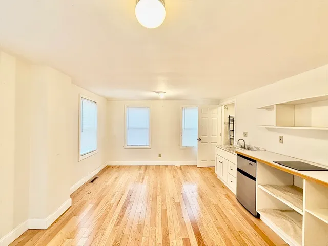 a view of a kitchen with a sink and wooden floor