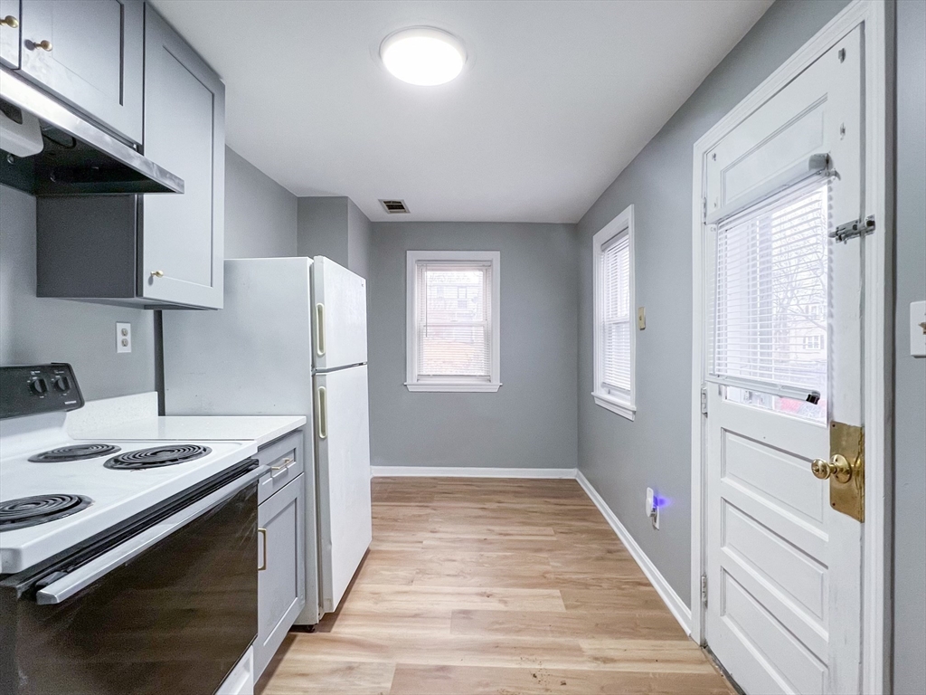 19-25 Common Street Weymouth, MA 02188 - Photo 4 of 41 a hallway with a stove top oven a refrigerator and a cabinets