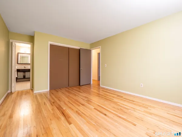 a view of empty room with wooden floor and entryway