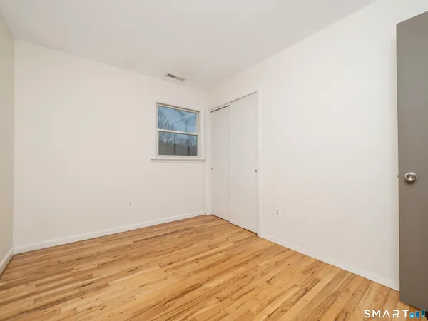 a view of empty room with wooden floor