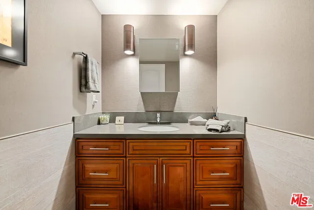 a bathroom with a granite countertop sink and a mirror