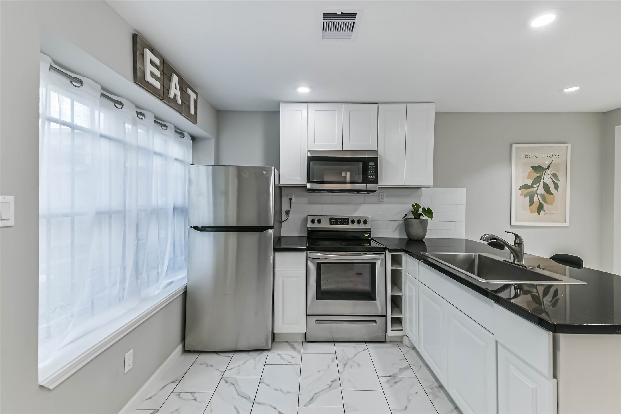 6853 Chasewood Drive Houston, TX 77489 - Photo 8 of 29 a kitchen with a sink a refrigerator and a stove top oven with wooden cabinets
