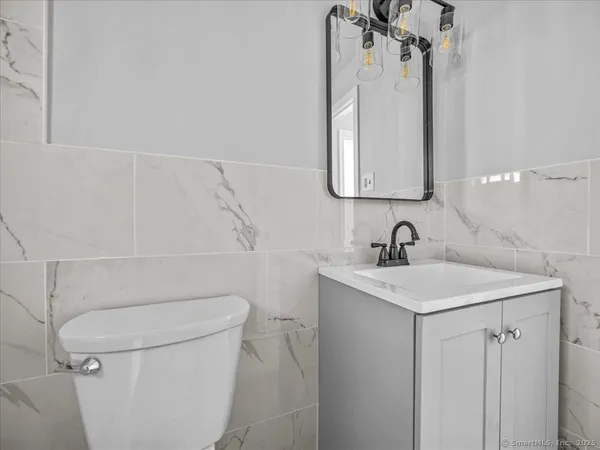 a bathroom with a sink a toilet and a mirror
