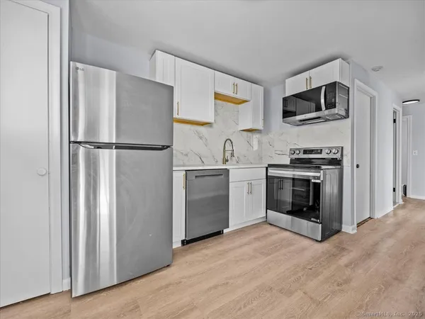 a kitchen with stainless steel appliances a refrigerator sink and stove