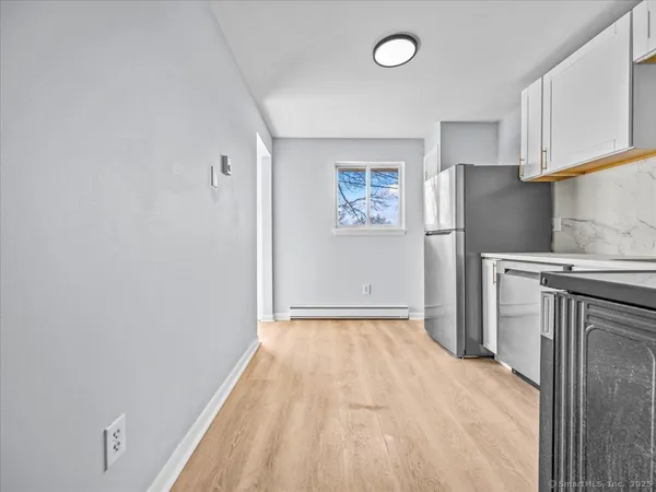 a view of a kitchen with refrigerator and cabinets