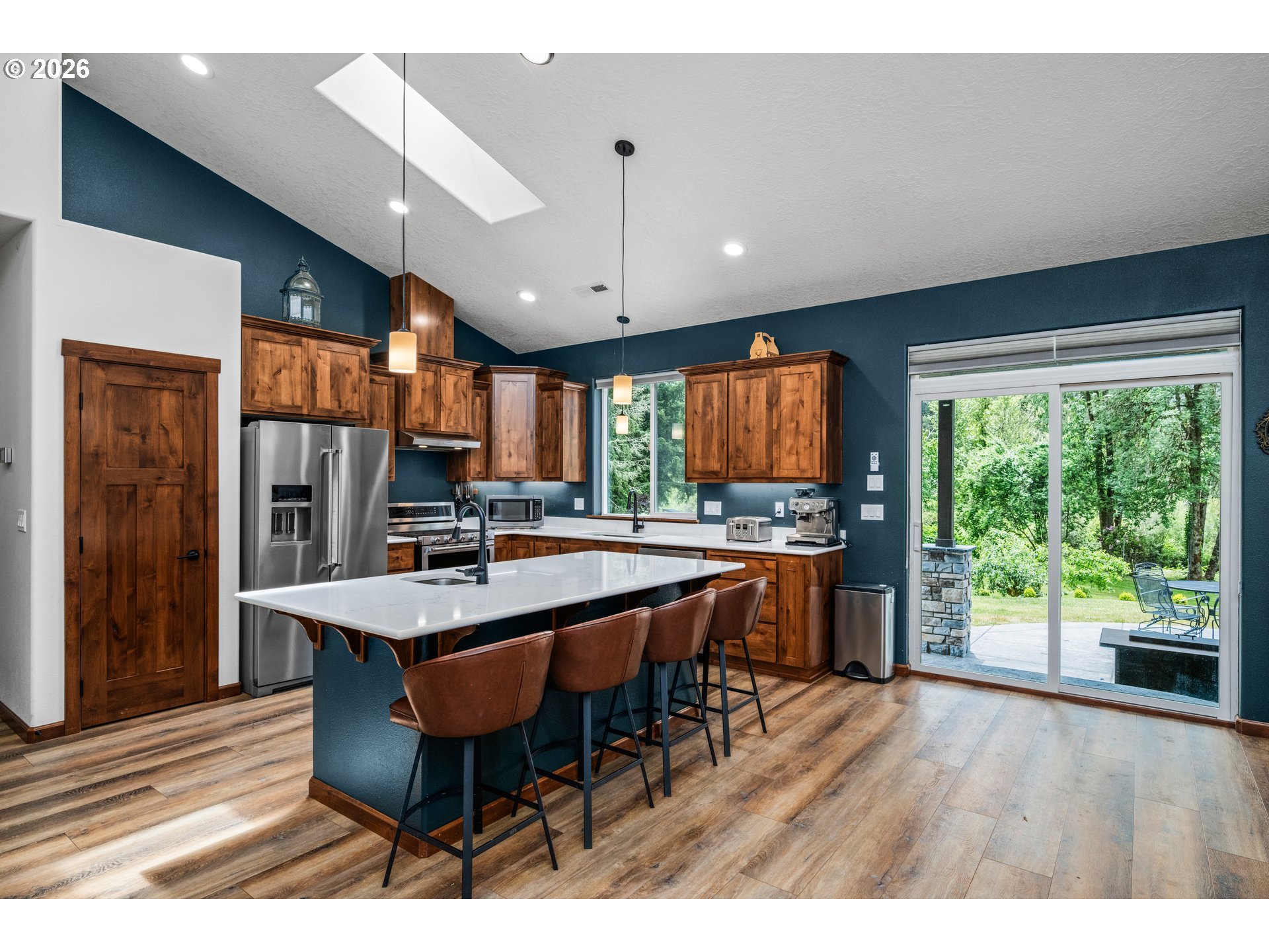 45542 South Gate Creek Road Vida, OR 97488 - Photo 28 of 46 a dining hall with stainless steel appliances granite countertop a refrigerator a sink dishwasher a dining table and chairs with wooden floor