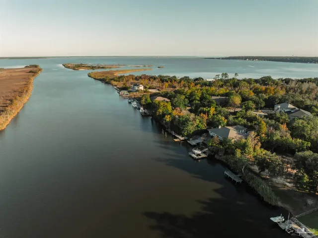 an aerial view of ocean and residential houses with outdoor space
