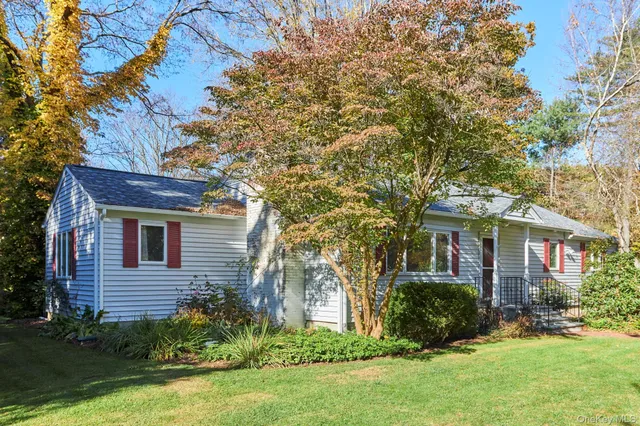 a front view of a house with a yard and trees