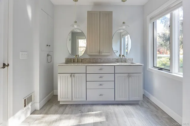 a view of a bathroom with mirror and window