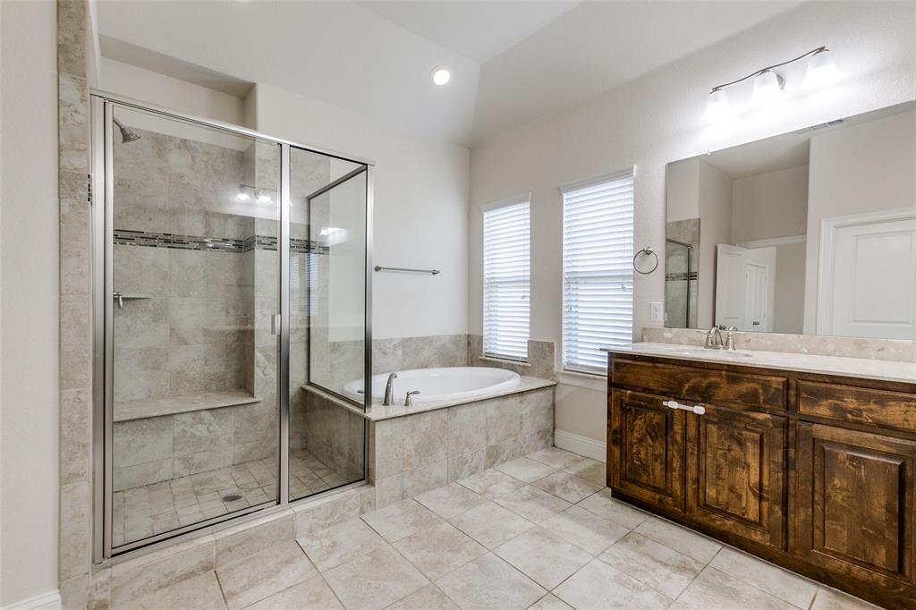 12618 Akenside Road Frisco, TX 75035 - Photo 16 of 31 Bathroom featuring tile patterned flooring, plus walk in shower, vanity, and lofted ceiling