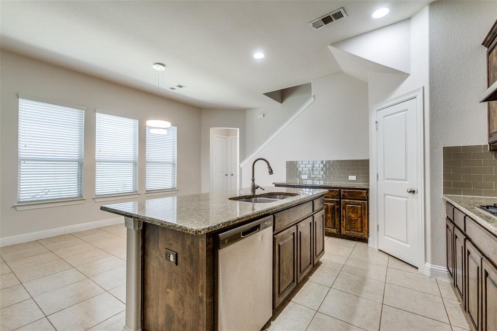12618 Akenside Road Frisco, TX 75035 - Photo 9 of 31 Kitchen featuring light tile patterned flooring, a wealth of natural light, sink, stainless steel dishwasher, and tasteful backsplash