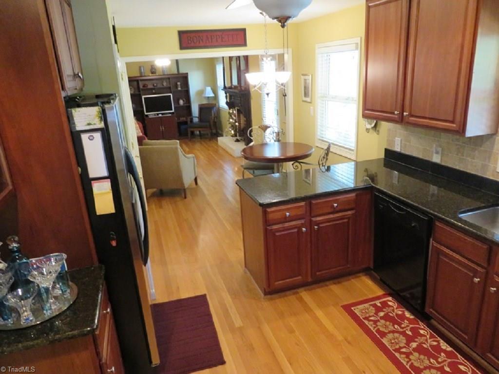 221 Pine Ridge Drive High Point, NC 27262 - Photo 9 of 25 Open kitchen, breakfast, den concept with door leading to sunroom