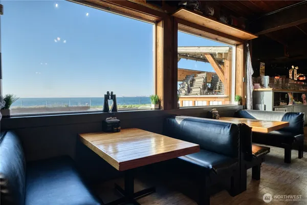 a kitchen filled with stainless steel appliances kitchen island granite countertop a table chairs in it and a wooden floor