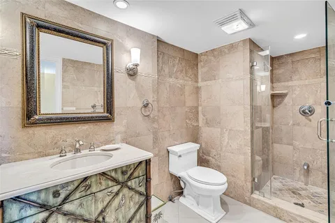 a bathroom with a sink toilet a mirror and shower