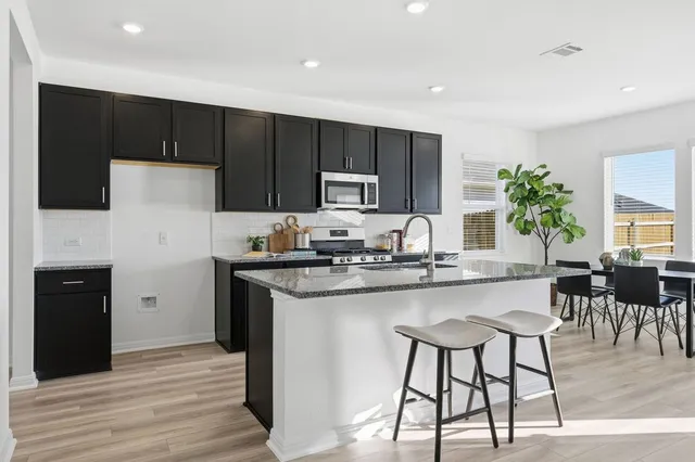 a kitchen with kitchen island granite countertop a cabinets and appliances