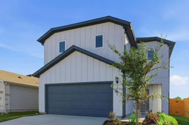 a front view of a house with plants
