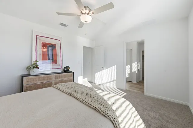 a bedroom with a large bed and a chandelier