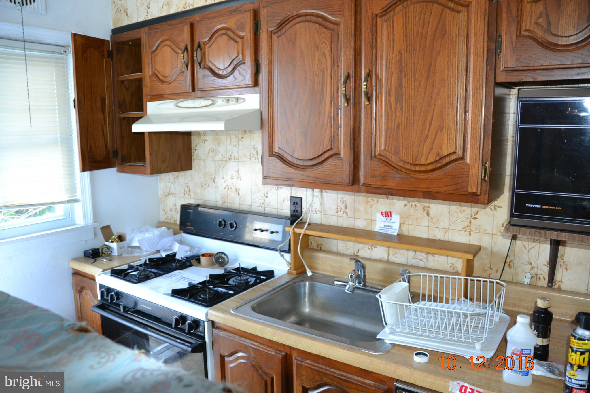 8544 Kavanagh Road Baltimore, MD 21222 - Photo 8 of 14 a kitchen with a stove and a microwave