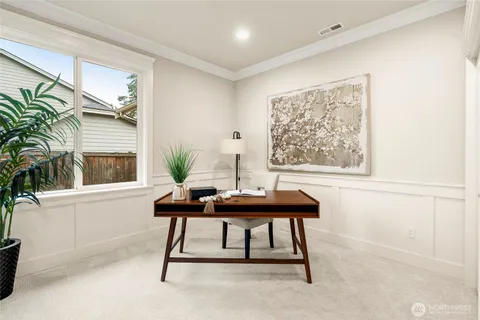 a view of a workspace with furniture and a window