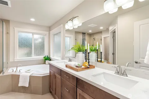 a bathroom with a granite countertop sink mirror and a bathtub