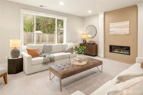 a living room with furniture a fireplace and a large window