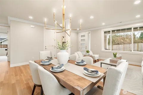 a dining room with furniture a large window and kitchen view