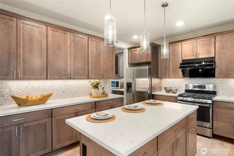 a kitchen with a sink a stove and chairs
