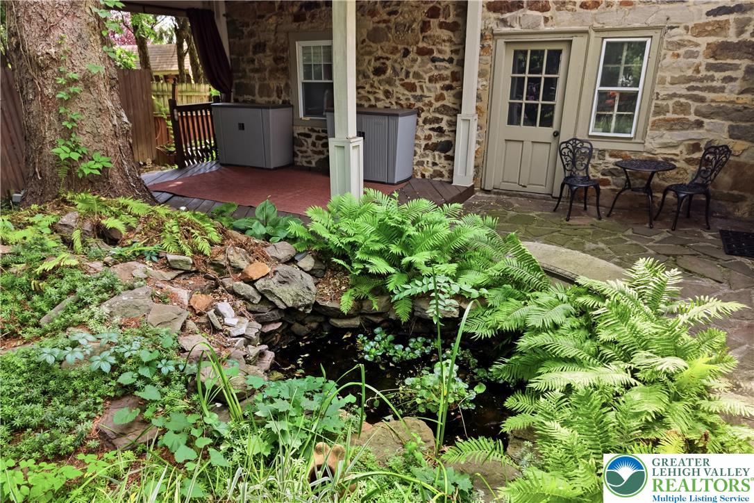 2014 Linden Street Bethlehem, PA 18017 - Photo 65 of 85 A stone-clad home's inviting outdoor space features a tranquil water feature, lush ferns, and an intimate patio.