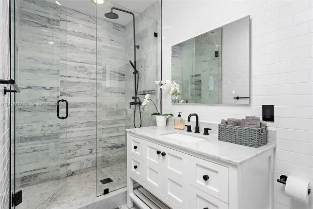 a bathroom with a sink shower and a mirror