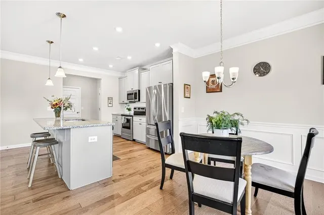 a kitchen with kitchen island white cabinets and stainless steel appliances