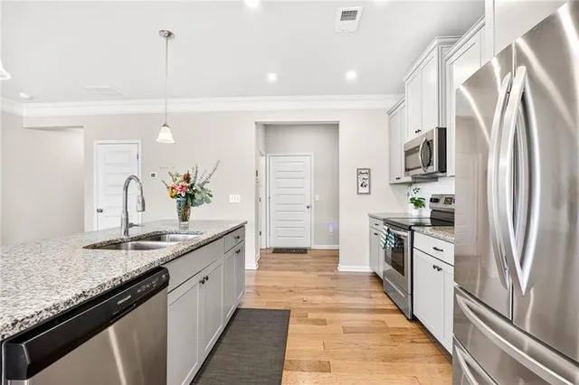 a large kitchen with granite countertop a sink and stainless steel appliances