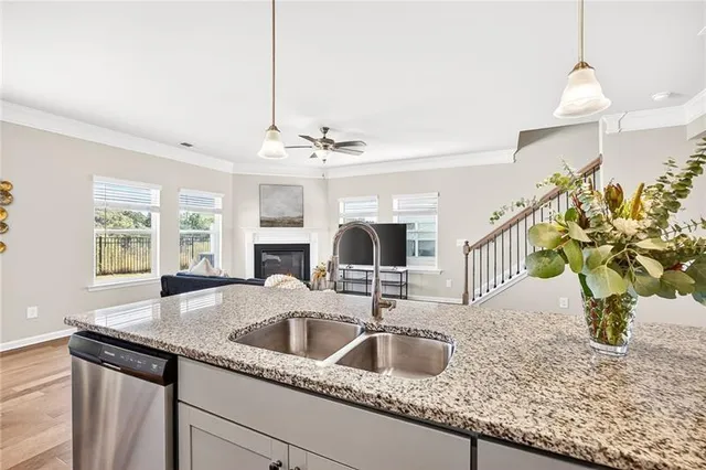 a kitchen with stainless steel appliances granite countertop a dining table chairs sink refrigerator and microwave