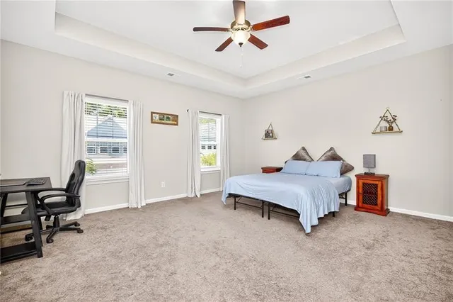 a spacious bedroom with a bed and a ceiling fan