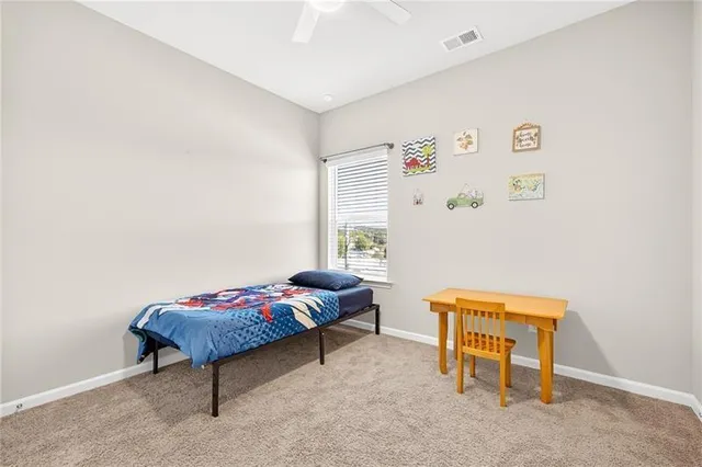 a bedroom with a bed a table and a chair