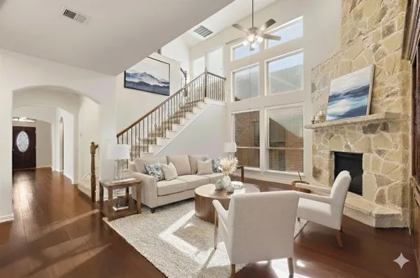 a living room with furniture a fireplace and a floor to ceiling window
