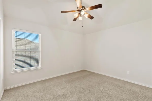 an empty room with closet and a chandelier fan
