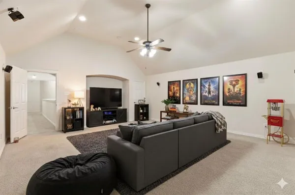 an empty room with chandelier fan and windows